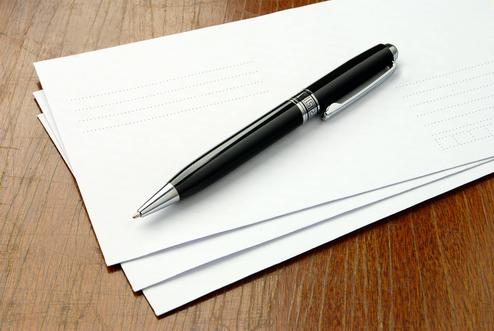 Trauerbriefe mit Stift Drei weiße Briefe, auf denen ein schwarzer Stift liegt