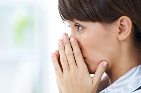 Trauernde Frau, die sich die Hände ins Gesicht hält und in die Ferne blickt Trauernde Frau, die sich die Hände ins Gesicht hält und in die Ferne blickt